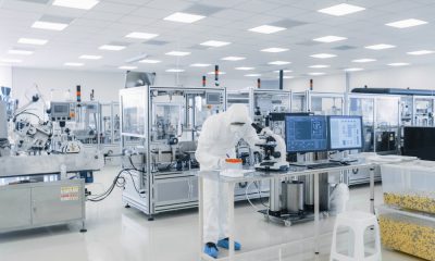 A technician uses machinery to complete a task during the pharmaceutical manufacturing process.